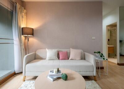 Cozy living room with white sofa, decorative cushions, and coffee table