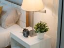 Bedside table with lamp and digital clock in a bedroom