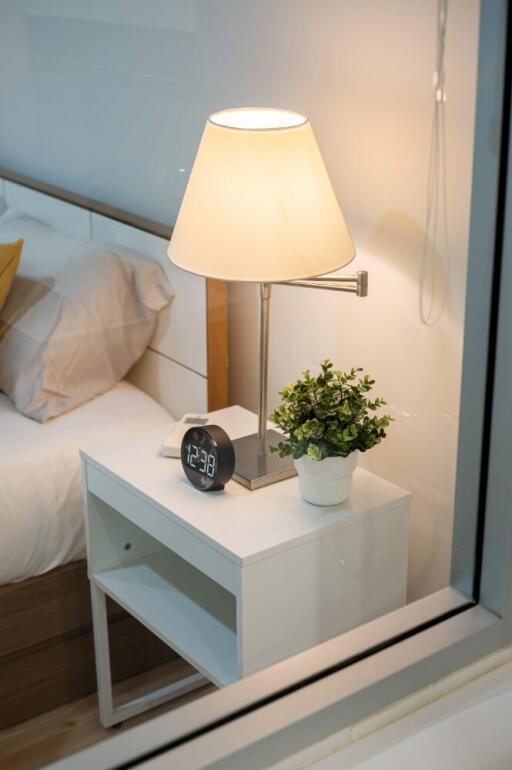 Bedside table with lamp and digital clock in a bedroom