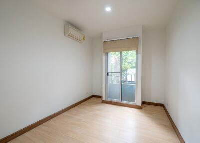 Empty bedroom with wooden flooring and large window