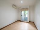 Empty bedroom with wooden flooring and large window