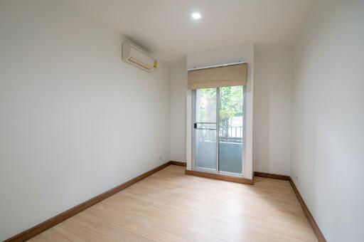 Empty bedroom with wooden flooring and large window