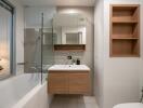 Modern bathroom with a bathtub, shower, sink, and built-in shelves