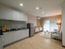 Modern open-plan kitchen and living room with light wood flooring