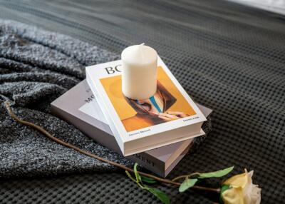 Book with candle on bed