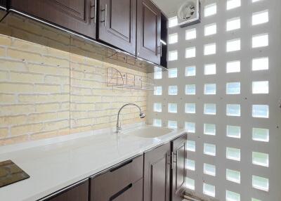 Modern kitchen with dark cabinets and brick backsplash