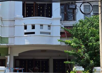 Front view of a residential building with a gated entrance and balconies