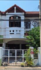 Front view of a residential building with a gated entrance and balconies