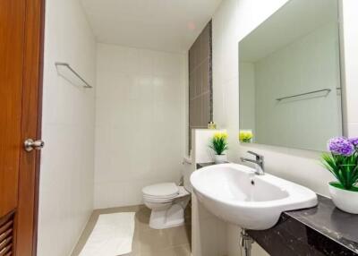 Modern bathroom with a sink, toilet, and mirror