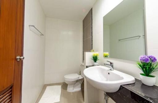 Modern bathroom with a sink, toilet, and mirror