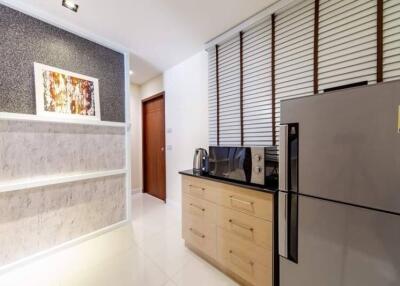 Modern kitchen with fridge, microwave, and storage