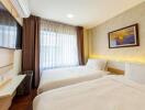 Modern bedroom with twin beds, wall-mounted TV, and framed art