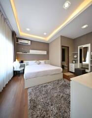 Modern bedroom with large bed, ambient lighting, and stylish decor