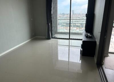 Empty living room with a city view through large windows