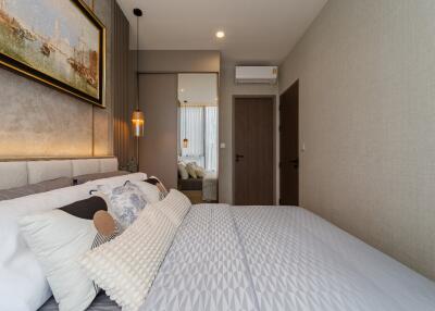 Modern bedroom with decorative pillows, artwork, and a large mirror