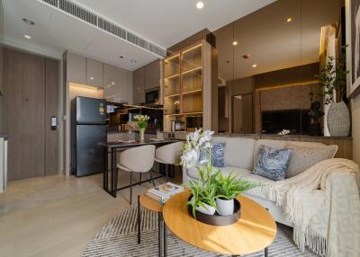 Stylish living room with integrated kitchen featuring modern appliances and cozy seating area