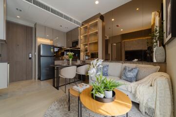 Stylish living room with integrated kitchen featuring modern appliances and cozy seating area