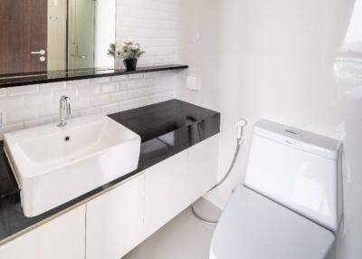 Modern bathroom with sink, toilet, and mirror