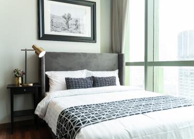 Modern bedroom with a bed, nightstand, and large window