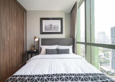 Modern bedroom with a large window and city view