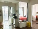 View of an apartment interior showing a small dining area, glass-enclosed kitchen, and two bedrooms