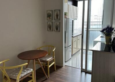 Small dining area with table and two chairs adjacent to modern kitchen