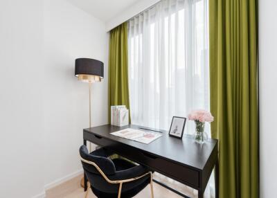 Bright home office with desk and green curtains