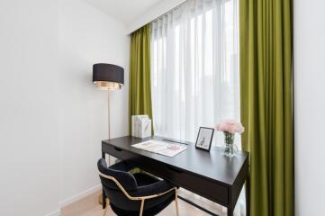 Bright home office with desk and green curtains