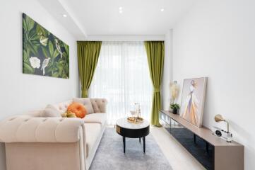 Contemporary living room with a beige sofa, green curtains, and decorated with modern art pieces.