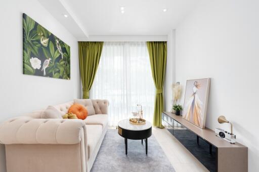 Contemporary living room with a beige sofa, green curtains, and decorated with modern art pieces.