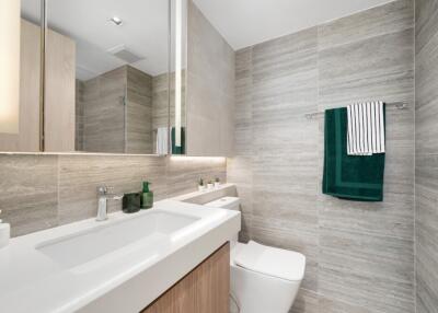 Modern bathroom with sink, toilet, and towels