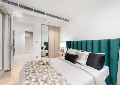 Modern bedroom with green headboard and decorative pillows