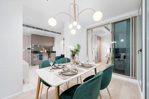 Modern dining area with elegant decor, adjacent kitchen and view into living room