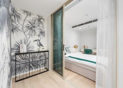 Bedroom with sliding glass door and tropical wallpaper