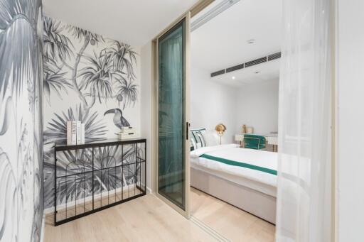 Bedroom with sliding glass door and tropical wallpaper