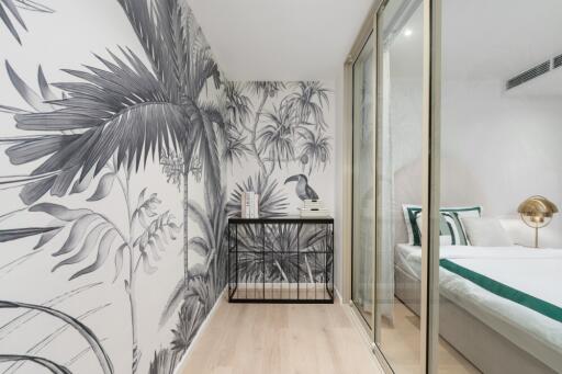 Stylish bedroom with tropical-themed wallpaper and glass sliding door