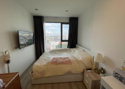 Spacious bedroom with a large window and city view