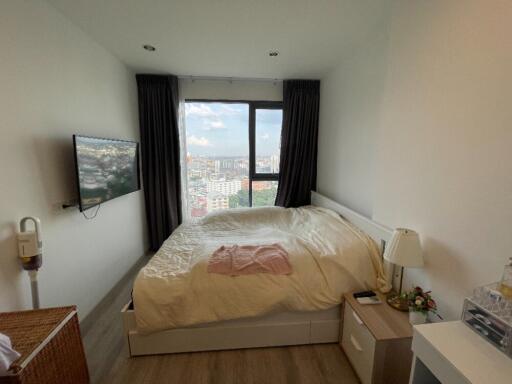 Spacious bedroom with a large window and city view