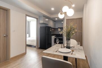 Modern dining area with view into the kitchen and a bedroom