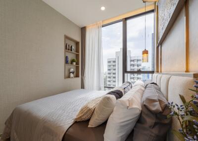 Modern bedroom with a large window and cozy bedding