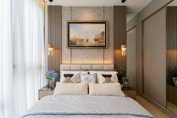 A modern, well-decorated bedroom with a comfortable bed, stylish lighting, and a large painting above the headboard.