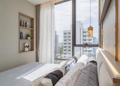 Cozy and modern bedroom with a large window offering city views.