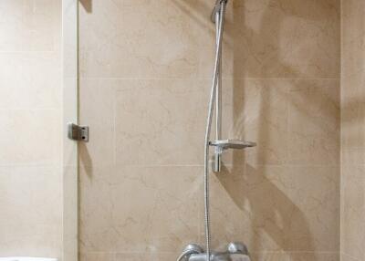 Shower area in a bathroom with beige tiles