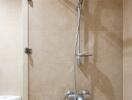 Shower area in a bathroom with beige tiles