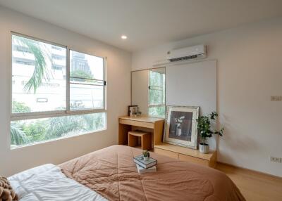 Bedroom with bed, large window, mirror, desk, and air conditioner