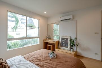 Bedroom with bed, large window, mirror, desk, and air conditioner