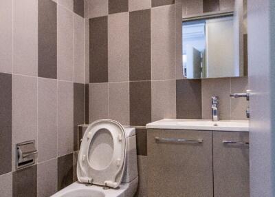 Modern bathroom with tiled walls and a toilet