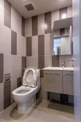 Modern bathroom with tiled walls and a toilet