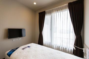 Cozy bedroom with a bed, window, and TV