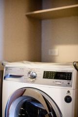 Washing machine in a laundry area with shelves